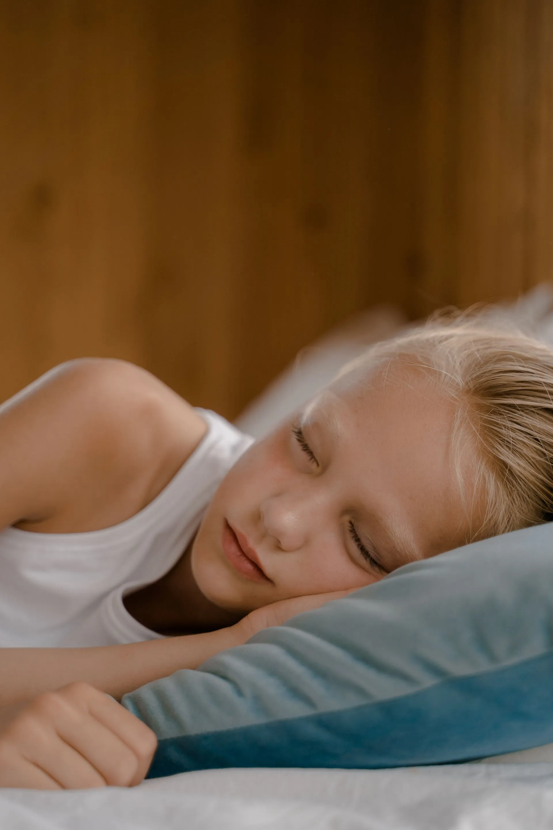 A young child sleeping peacefully on a soft pillow